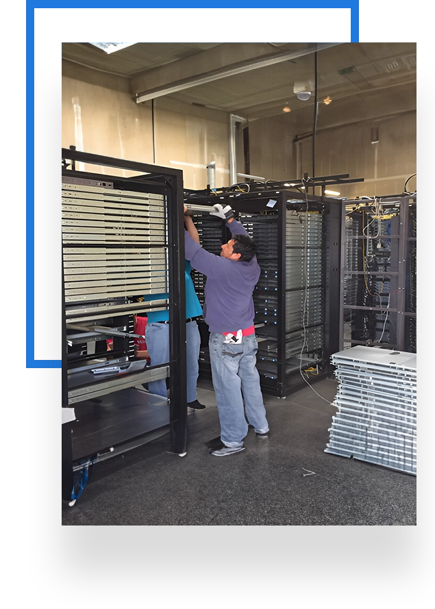 A man working in an industrial setting with racks of metal.